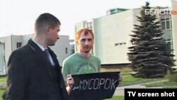 Activist Ivan Amelchanka (right) pictured with the offending sign