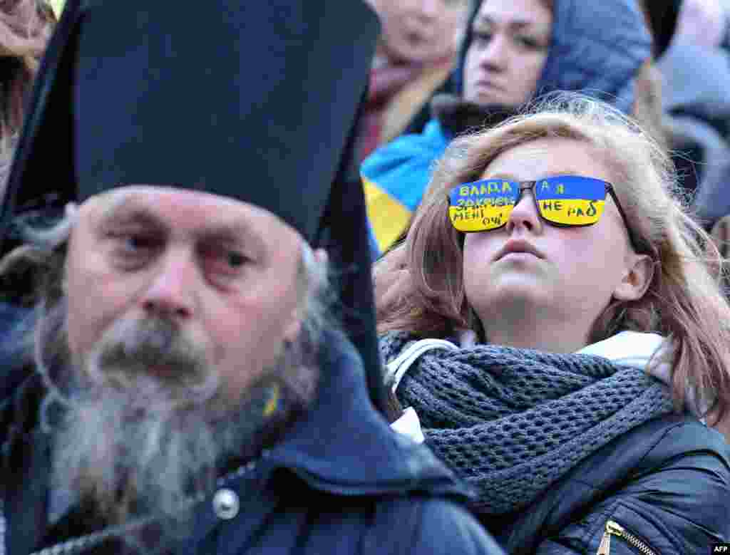 A girl wearing glasses reading &quot;Power closes my eyes. I am not a slave&quot; takes part in an antigovernment march in the western Ukrainian city of Lviv. (AFP/Yuriy Dyachshyn)&nbsp;