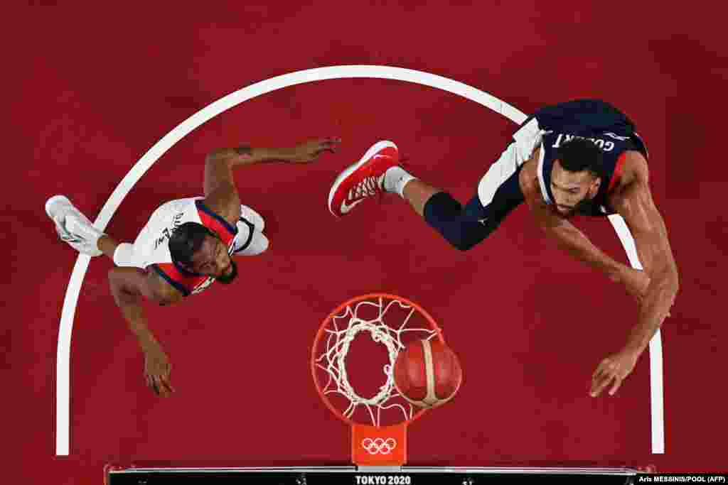Француз Руди Гобер (справа) и Кевин Уэйн Дюрант из США смотрят на корзину в финальном мужском баскетбольном матче между Францией и США на Олимпийских играх 2020 года в Токио, 7 августа 2021 года