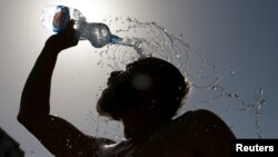 Човек се разладува со шише вода во Скопје