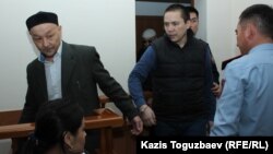 "Жиһадшылар ісі" бойынша сотталушылар Кенжебек Әбішев (сол жақта) пен Алмат Жұмағұловты сотқа алып келе жатыр. Алматы, 26 қыркүйек 2018 жыл.