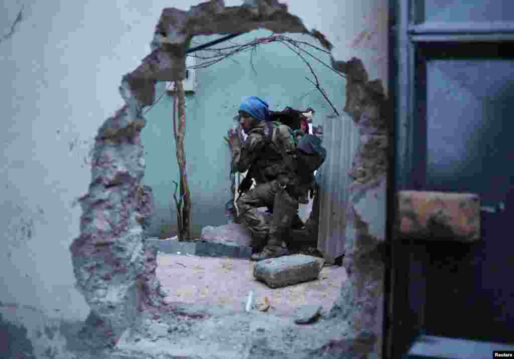 An Iraqi special forces soldier moves through a hole as he searches for Islamic State fighters on February 27.&nbsp;