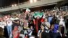 IRAN -- Iranian soccer supporters wave their national flags as they cheer for their national team during a screening of the Russia 2018 World Cup Group B football match between Iran and Spain in Azadi stadium in the capital Tehran, June 20, 2018