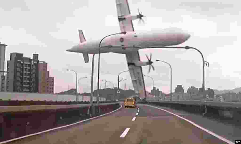A video grab shows a TransAsia ATR 72-600 turboprop plane clipping an elevated motorway and hitting a taxi before crashing into the Keelung River outside Taiwan's capital, Taipei. At least 31 people were killed in the crash, with 12 still missing and 15 survivors. (AFP)