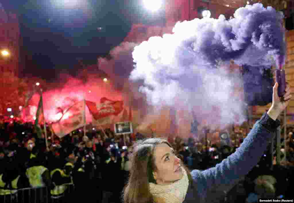 Anna Donath, vice president of the opposition party Momentum Movement, holds a flare during a protest against a proposed new labor law, billed as the &quot;slave law,&quot; in Budapest. (Reuters/Bernadett Szabo)