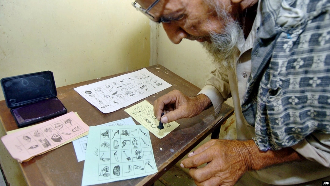 A Pakistani man marks his ballot in Karachi during elections in August 2005.