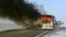 The burning bus is seen by the side of the highway near Aqtobe.