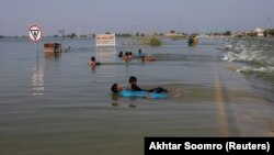 Boys play in floodwaters on the main Indus highway in Sehwan, Pakistan, on September 15.