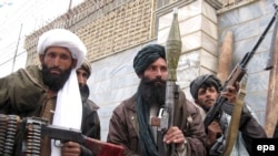 Former Taliban fighters attend a ceremony as they surrender their weapons.