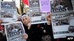 Turkey -- Supporters of Zaman hold copies of the Turkish newspaper during a demostration against the arrest of journalists outside the Istanbul police headquarters, December 15, 2014