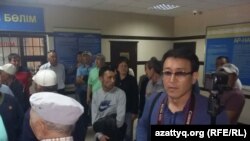 Полиция ұстаған Азаттық тілшісі Асылхан Мамашұлы (оң жақта) полиция ұстаған өзге де азаматтар Әуезов аудандық ішкі істер басқармасында. Алматы, 21 мамыр 2016 жыл. 