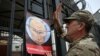 A demonstrator puts up a poster depicting Russian President Vladimir Putin during a rally to commemorate the fourth anniversary of the battle in the eastern city of Ilovaysk, in front of the Russian Embassy in Kyiv, on August 29.