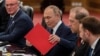 Presidenti rus, Vladimir Putin, me një dosje të kuqe.