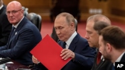 Russian President Vladimir Putin organizes documents at a bilateral meeting with Chinese leader Xi Jinping in Beijing on September 2. 