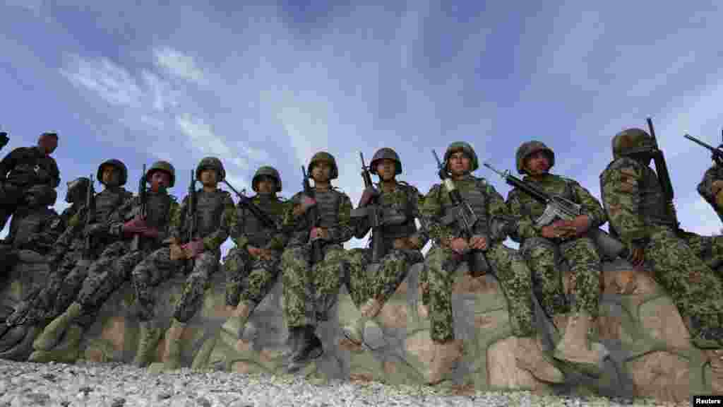 Afghan soldiers wait before a handover ceremony between the French Army and the Afghan National Army at Camp Nijrab in Kapisa Province as part of the withdrawal of French troops. French combat troops are due to pull out of Afghanistan by the end of the year. (Reuters/Eric Gaillard)