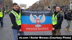 Activiști francezi de extrema dreaptă purtând pe Champs-Élysées steagul "Republicii din Donețk" la o manifestație a "vestelor galbene" în Paris.