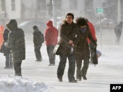 Пешеходы идут по улице Пекина в плохую погоду. 4 января 2010 года.