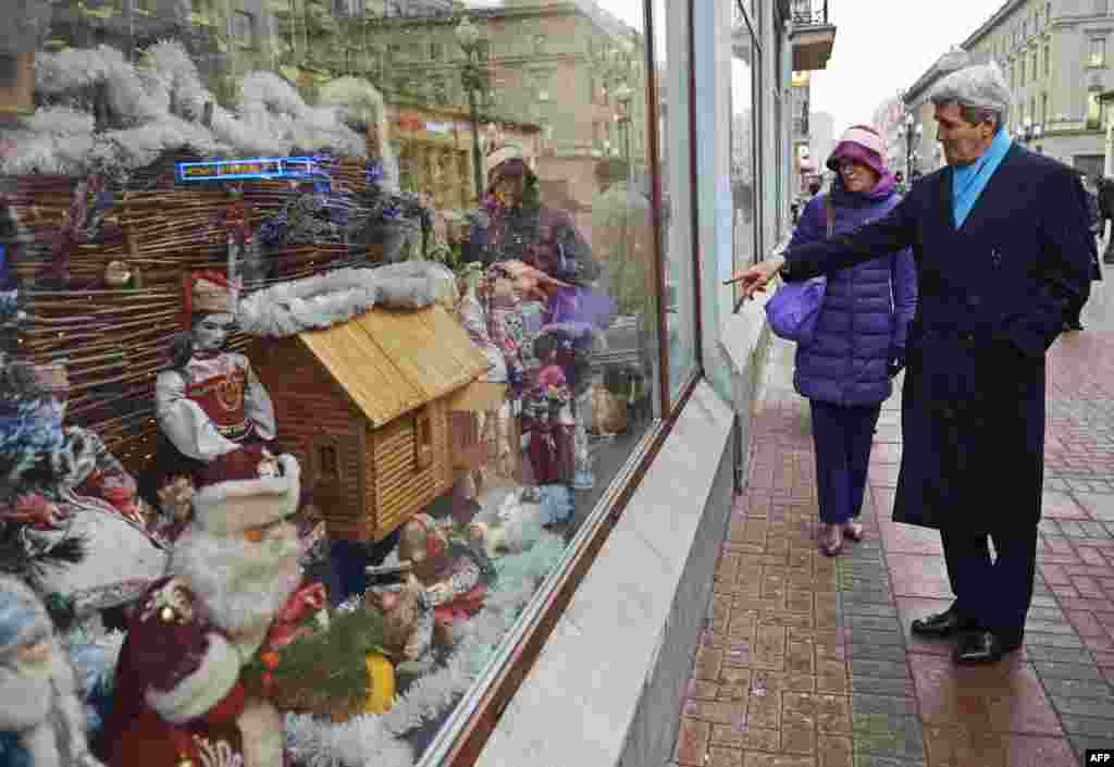 U.S. Secretary of State John Kerry (right) points to a store window while souvenir shopping with Celeste Wallander from the National Security Council, in Moscow on December 15. (AFP/Mandel Ngan)