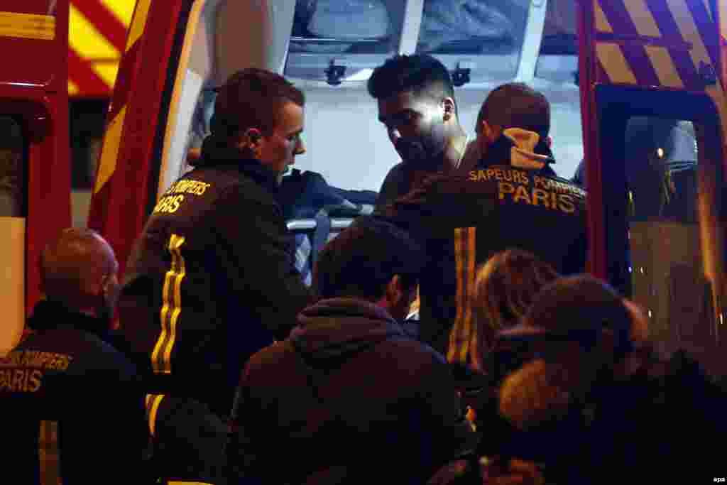 A wounded man is put into a fire truck next to the Stade de France where a number of explosions occurred in the north of Paris.