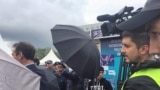 Белгісіз адамдар Азаттық тілшісінің видео түсіруіне кедергі жасап, камераны қолшатырмен жауып тұр. Астана, 9 маусым, 2019 жыл. 