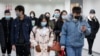 People wearing protective masks in a subway tunnel during evening rush hour in Beijing on March 10.