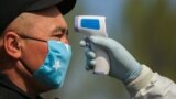 A security officer checks the temperature of a passenger in Bishkek.