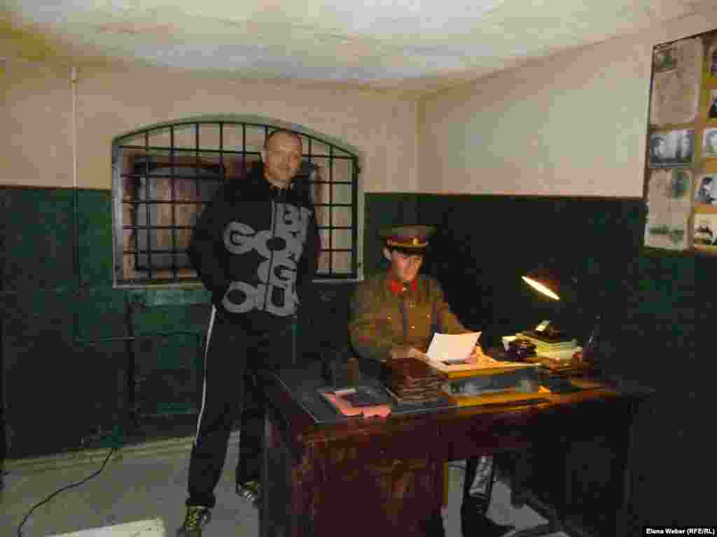 A visitor is photographed in the re-created office of a KarLAG officer, where new prisoners would be accepted and their personal files reviewed.