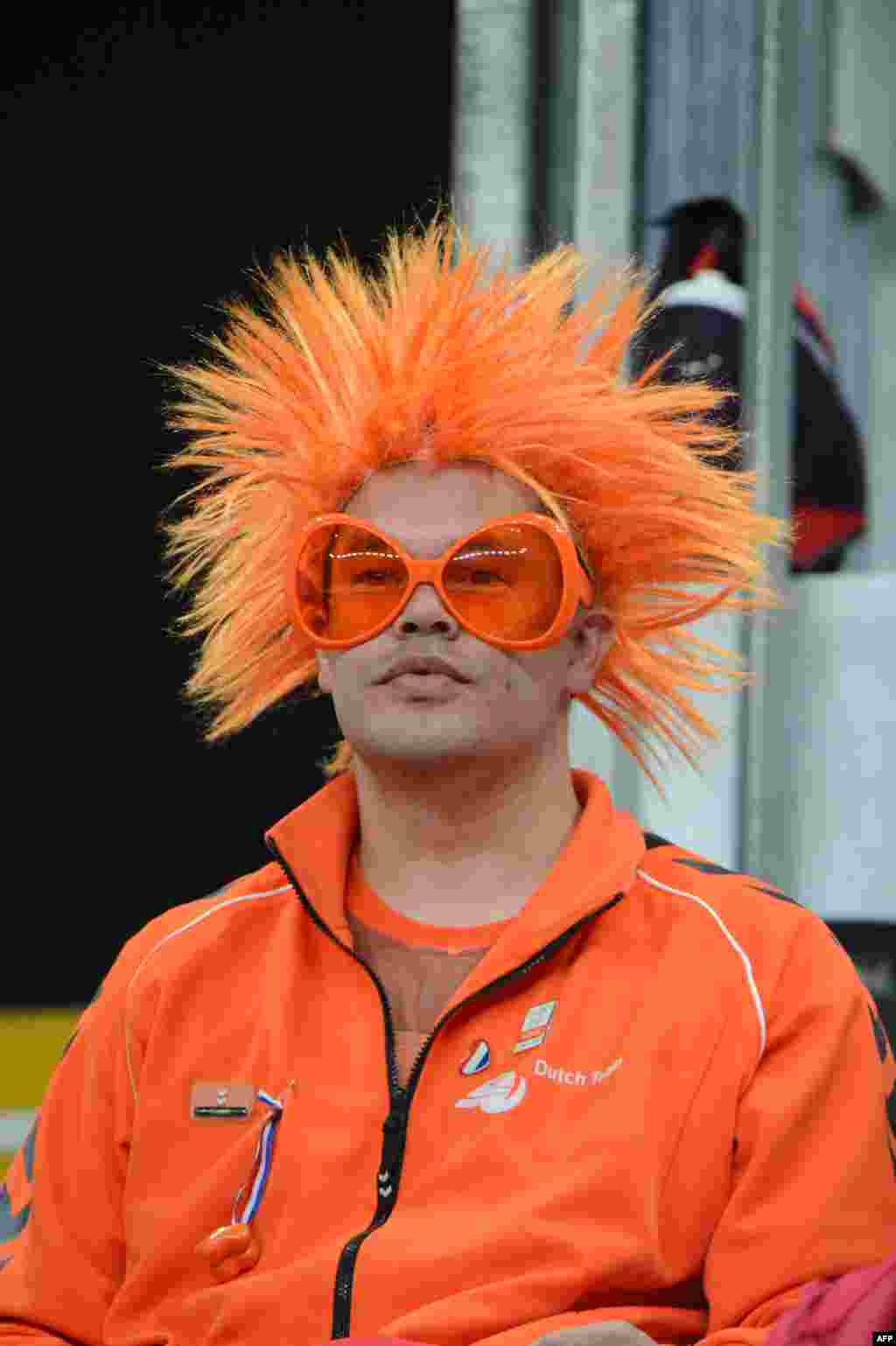 Нидерландский болельщик смотрит на баскетбольный матч между женскими командами Великобритании и Канады сквозь оранжевые очки.
