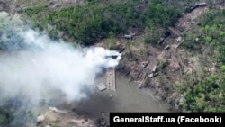 In an image released by Ukraine's military on May 12, what is said to be Russian Army equipment burns on the banks of the Severskiy Donets River in the Donbas. 