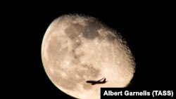 RUSSIA -- A passenger plane flies in front of full moon, Moscow, February 27, 2018