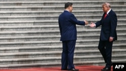US President Donald Trump (right) shakes hands with Chinese leader Xi Jinping at a welcome ceremony in Beijing on May 14.