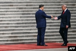 US President Donald Trump (right) shakes hands with Chinese leader Xi Jinping at a welcome ceremony in Beijing on May 14.