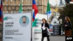 People in Novosibirks walk past a campaign tent for Sergei Boiko, who heads the local office of opposition politician Aleksei Navalny in Novosibirsk and is running for the city legislature.