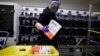 U.S. -- Election worker Gareth Fairchok removes ballots from a sorting machine as vote-by-mail ballots for the August 4 Washington state primary are processed at King County Elections in Renton, Washington on August 3, 2020.