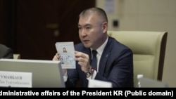 Президенттин иш башкаруучусу Каныбек Туманбаев жаңы паспорттун үлгүсүн кармап турат.