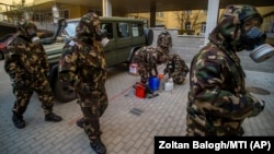 Hungarian soldiers wearing hazmat suits prepare to disinfect a kindergarten and elementary school in an effort to curb the spread of the coronavirus in Budapest on March 17.