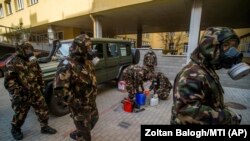 Militari pregătindu-se să dezinfecteze o grădiniță în Budapesta, 17 martie 2021