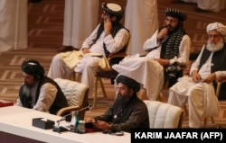 A tálibok társalapítója, Abdul Ghani Baradar molla (jobbra, alul) beszél az afgán kormány és a tálibok közötti béketárgyalások megnyitóján a katari fővárosban, Dohában 2020. szeptember 12-én.