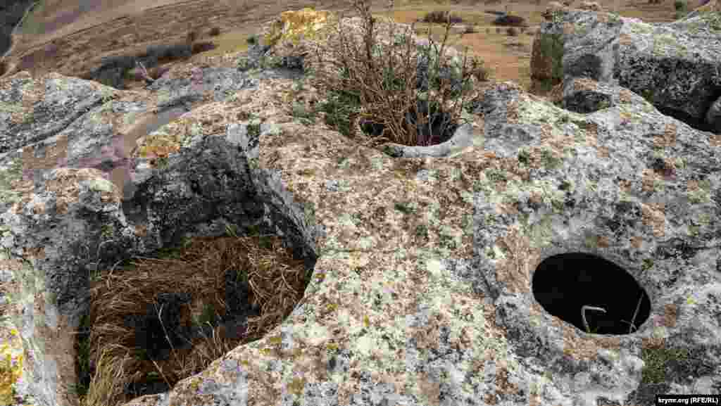 Тарапан (место, где давили виноград на вино) и зерновые ямы с круглыми отверстиями на самом краю обрыва