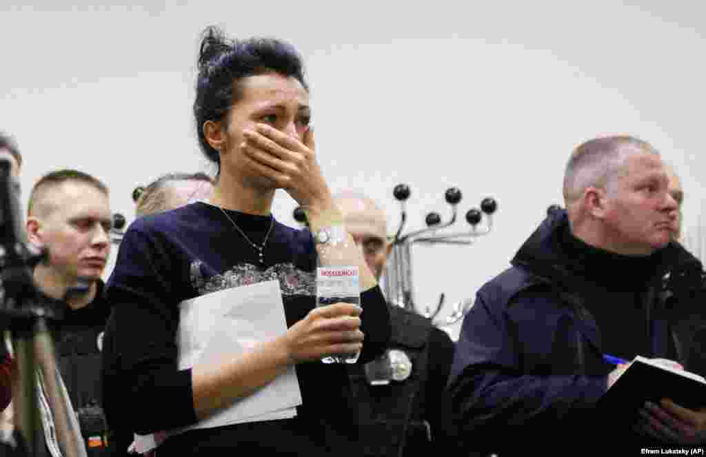 A Ukrainian International Airlines worker reacts to the news during a briefing at Boryspil International Airport outside Kyiv on January 8.