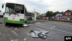 Russia -- People check the crash scene on July 13, 2013 near the village of Oznobikhino outside Moscow after at least 18 people were killed and at least 40 injured when a gravel truck smashed into a bus packed with passengers.
