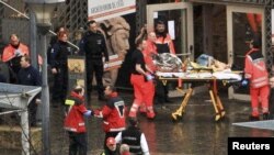 Rescuers evacuate injured people on Place Saint Lambert square in the city of Liege on December 13.