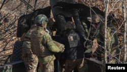 Militari ucraineni pregătesc încărcătura de artilerie înainte de un atac asupra trupelor rusești din regiunea Donețk, 11 martie 2024.