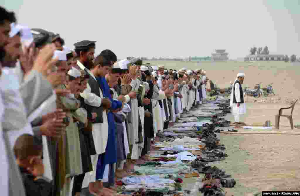 Afghan residents offer prayers at the start of Eid al-Fitr at an open air mosque on the outskirts of Jalalabad.