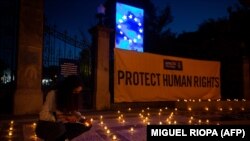 Egy nő gyertyát gyújt az EU-s társadalmi csúcs idejére az Amnesty International jogvédő szervezet által szervezett vigília idején 2021. május 6-án, Portóban