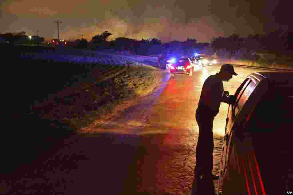 A law enforcement officer at a check point in West, Texas, after a massive explosion at a fertilizer factory in the town injured more than 100 people and left damaged buildings for blocks in every direction on April 18. The death toll from the blast, which occured as firefighters were tackling a blaze, is as yet unknown. (Getty Images-AFP/Chip Somodevilla.)