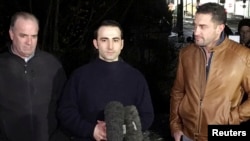 Amir Hekmati (center), flanked by U.S. congressman Dan Kildee (left), and his brother-in-law, Ramy Kurdi, speaks to the media in Landstuhl on January 19.
