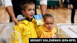 Дети с родителями на одном из избирательных участков в Киеве. Архивное фото