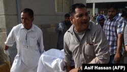 Pakistani paramedics push a stretcher carrying an injured Chinese national to an hospital after an attack by gunmen in Karachi on February 5.