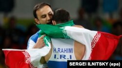 Iran's wrestling team is not at the World Cup in the United States after coach Rasoul Khadem (facing) recently quit.